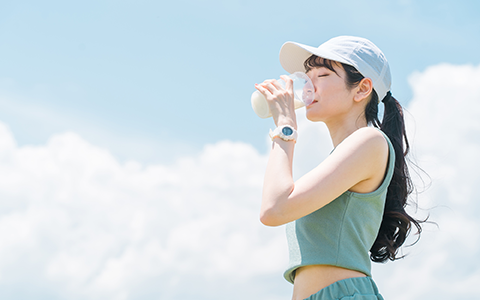プロテインを飲んで運動する女性の写真