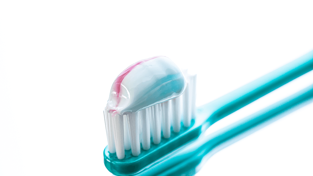 歯磨き粉を歯ブラシにのせてい写真