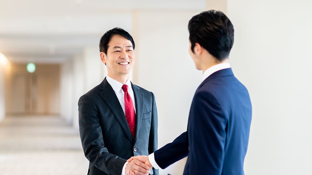 男性ビジネスマンが握手している写真
