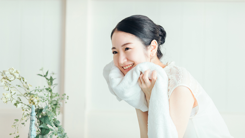 洗顔後、タオルで顔を拭いている女性の写真