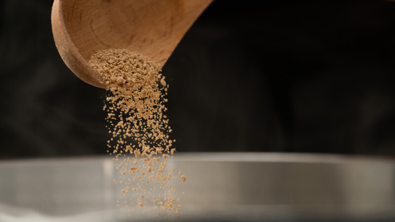 顆粒錠のものをスプーンから注いでいる様子の写真