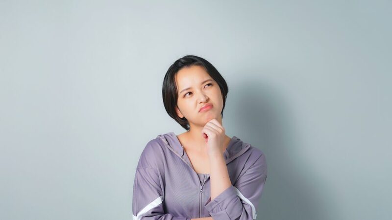 スポーツウェアを着た女性が悩んでいる写真