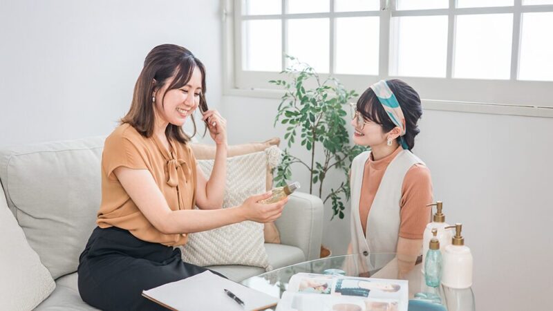 商品を手に取った女性と話を聞いている女性の写真
