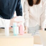 複数の容器を囲んで4人で話し合っている画像