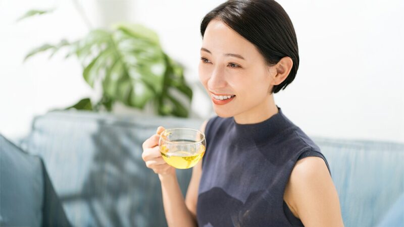 笑顔の女性がお茶を飲んでいる写真