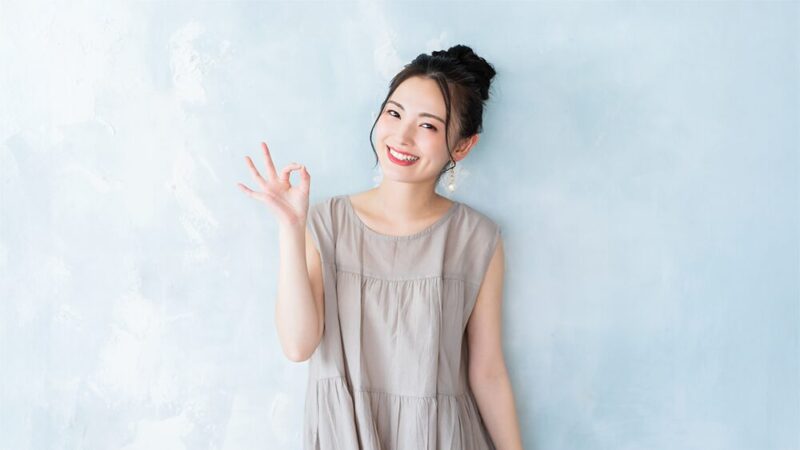 笑顔の女性が指で丸を作っている写真