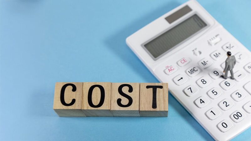 電卓と「COST」と書いている木製ブロックの写真