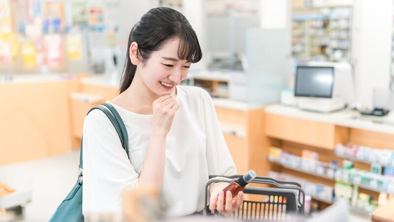 ショッピングカートを持った女性が商品を笑顔で見ている写真