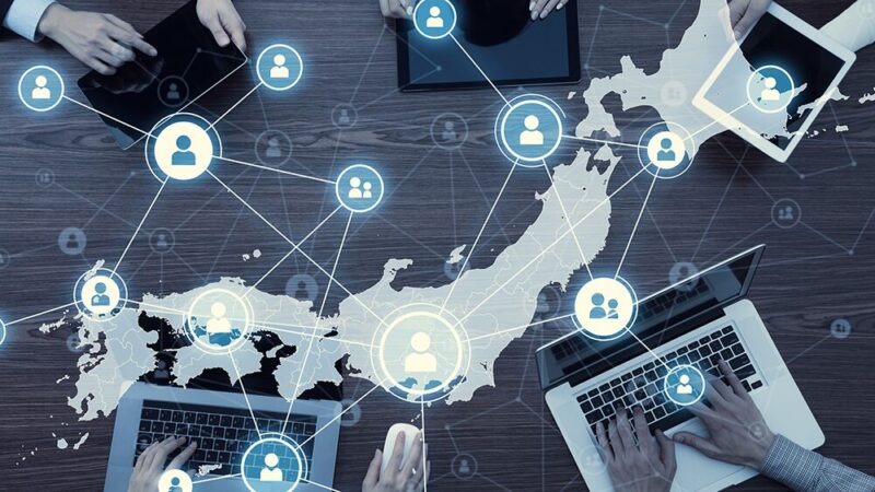 パソコンを持った人たちと日本地図・人のイラストのネットワークの写真