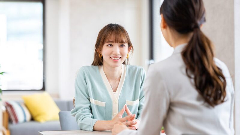 女性二人が向き合って、笑顔で話し合っている写真