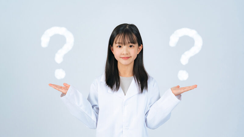 女性が左右に手を広げ、その手の上に？マークが表示されている写真