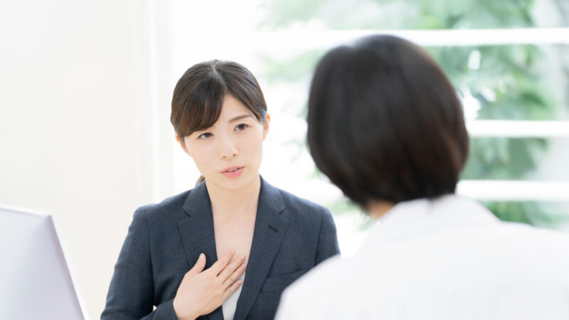 ビジネススーツを来た女性が説明をしている写真