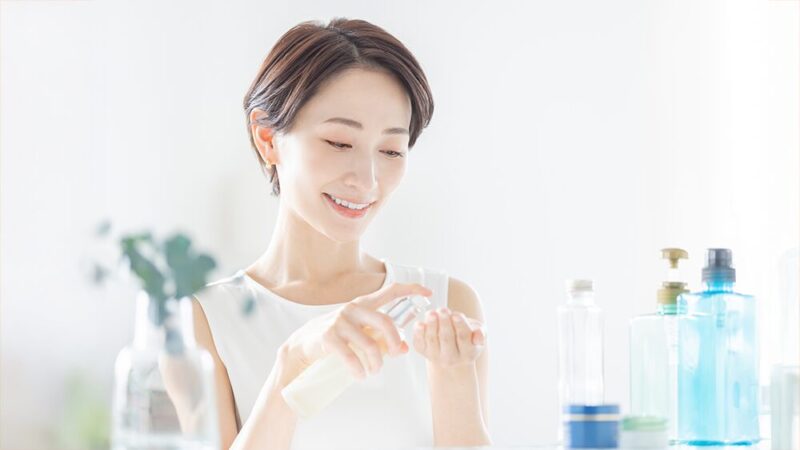 笑顔の女性が手に美容液を出している写真