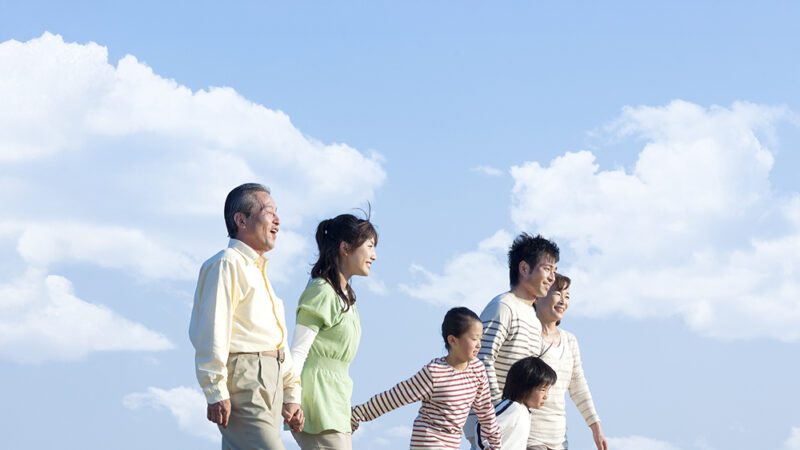 3世代の家族が手を繋いで仲睦まじく歩いている写真