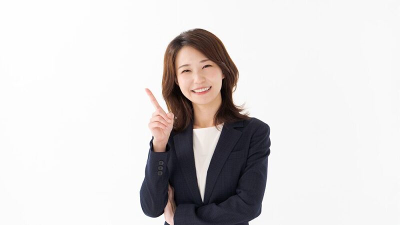 スーツの女性が人差し指を立てている写真