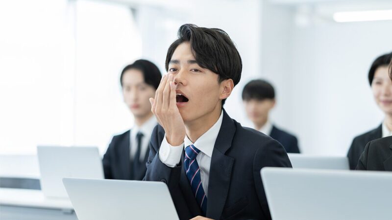 スーツの男性があくびをしている写真