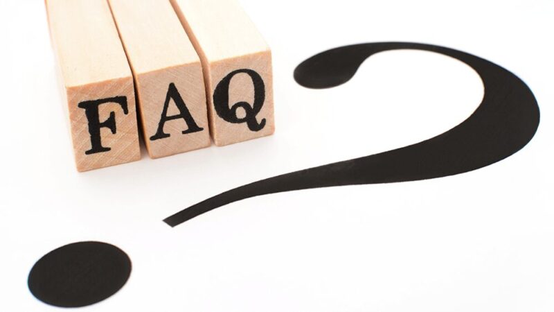 FAQと書いた木製ブロッと「？マーク」が書いている紙の写真