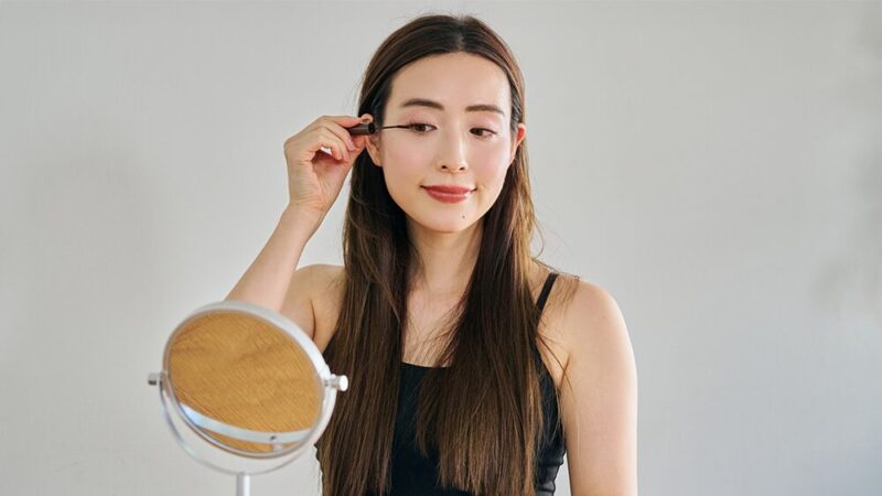女性がまつ毛にブラシで塗っている写真