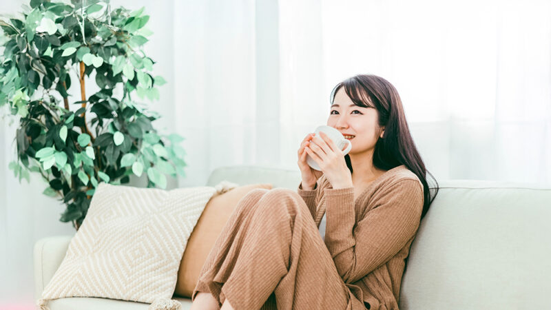 カップに入ったドリンクを飲んでリラックスする女性