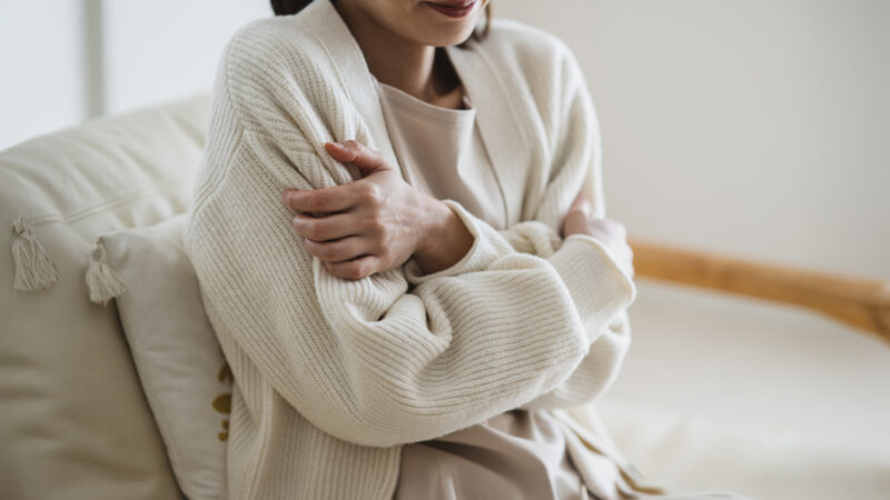 体を抱えて冷えに悩む女性
