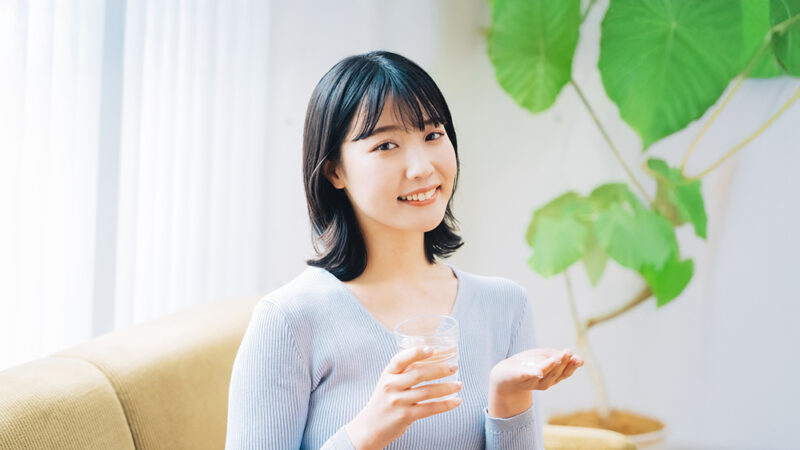 サプリメントを持ち笑顔の女性