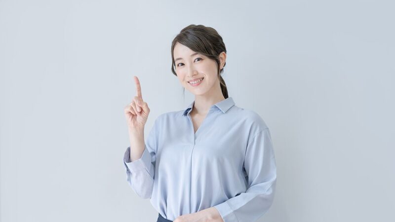 スーツの女性が人差し指を立てている写真