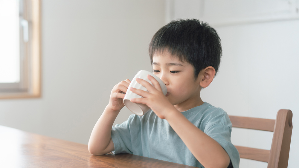 子どもがカップでドリンクを飲む様子
