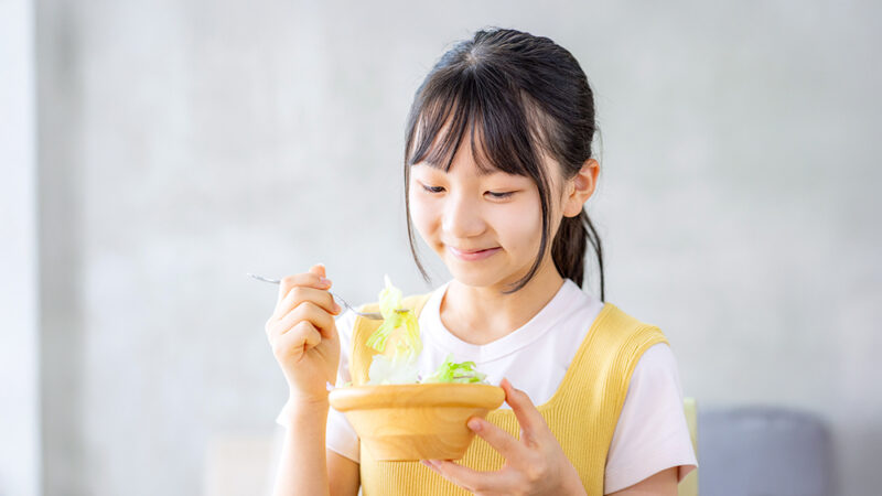 おいしそうに食事をしているう女の子の写真