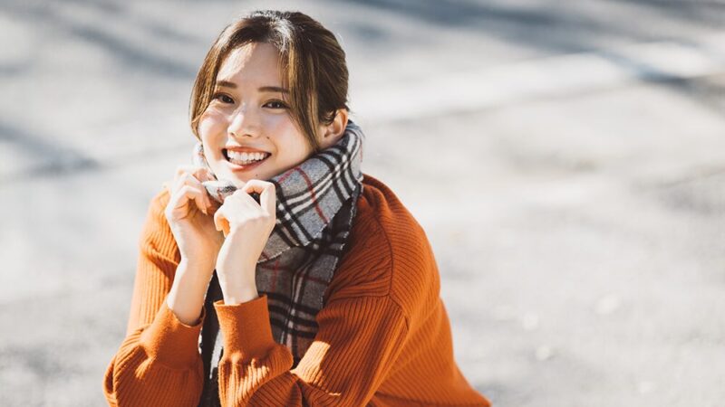 マフラーをまいた女性が笑っている写真
