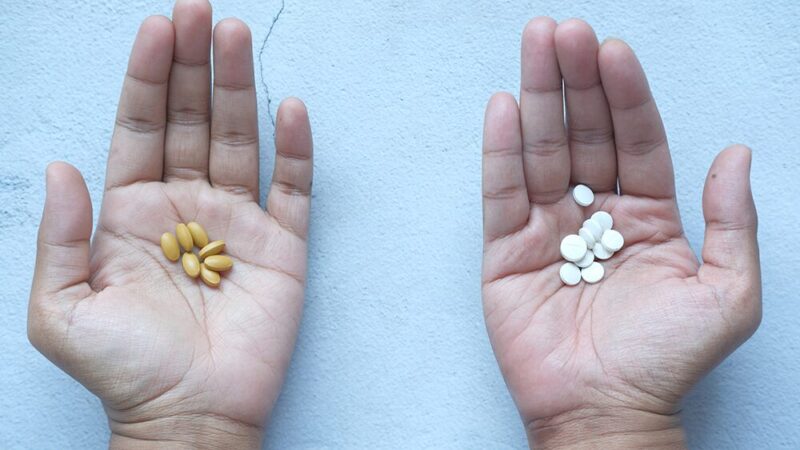 両手に種類の違う錠剤を乗せている写真