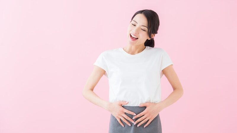 おなかに手を当てている女性の写真