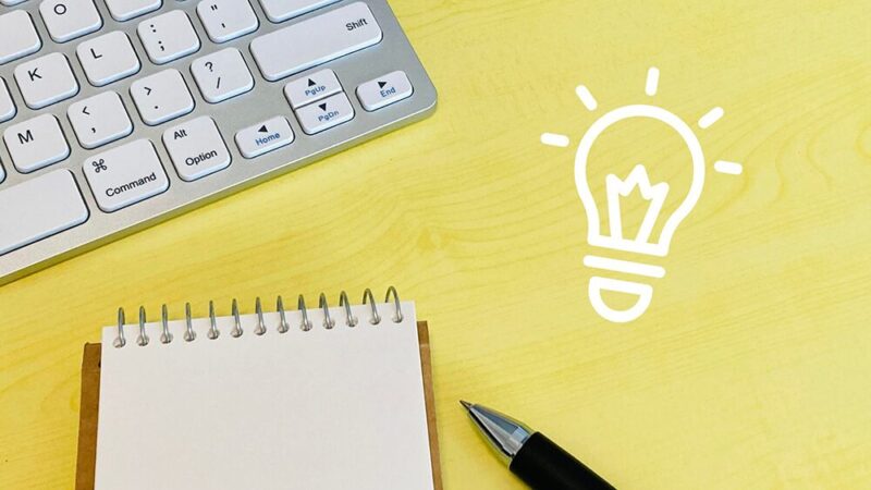 キーボードとメモと電球のイラストの写真