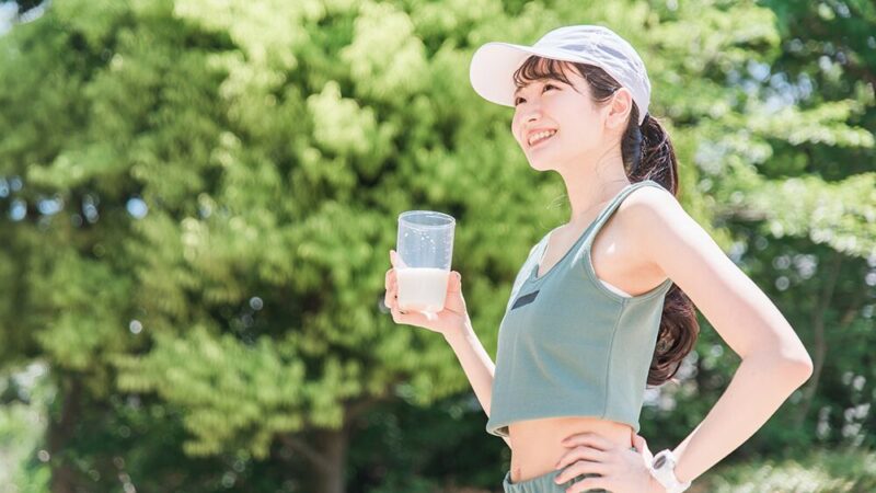 スポーツウェアで右手にドリンクを持っている女性の写真