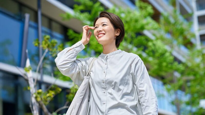 中年女性が笑顔で屋外を歩いている写真