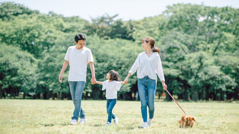 ペット連れの親子が公園にいる写真