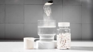 水の入ったコップと粉末や錠剤のサプリメントの写真