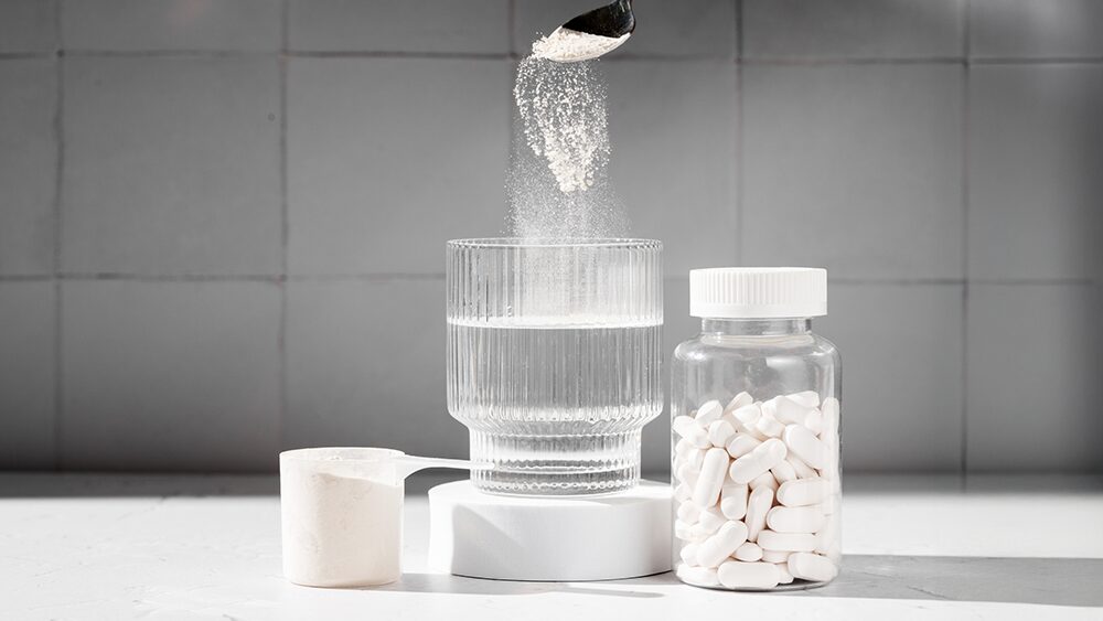 水の入ったコップと粉末や錠剤のサプリメントの写真