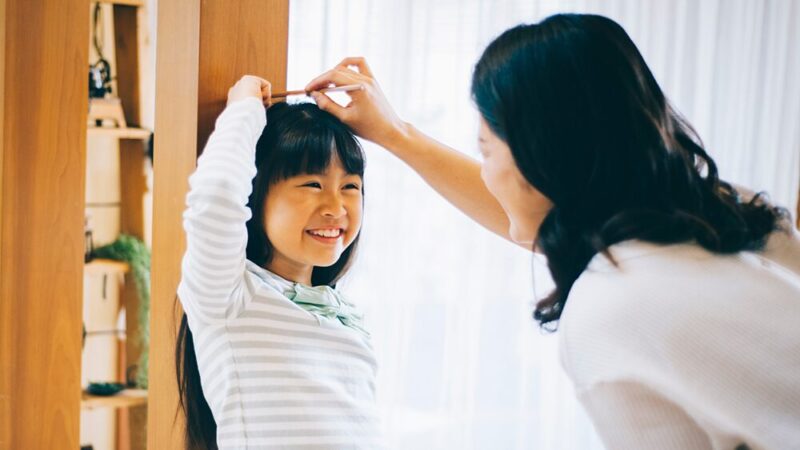 子どもの身長を測っている女性の写真