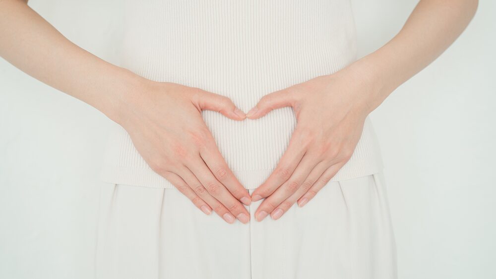 おなかに両手を当てている写真