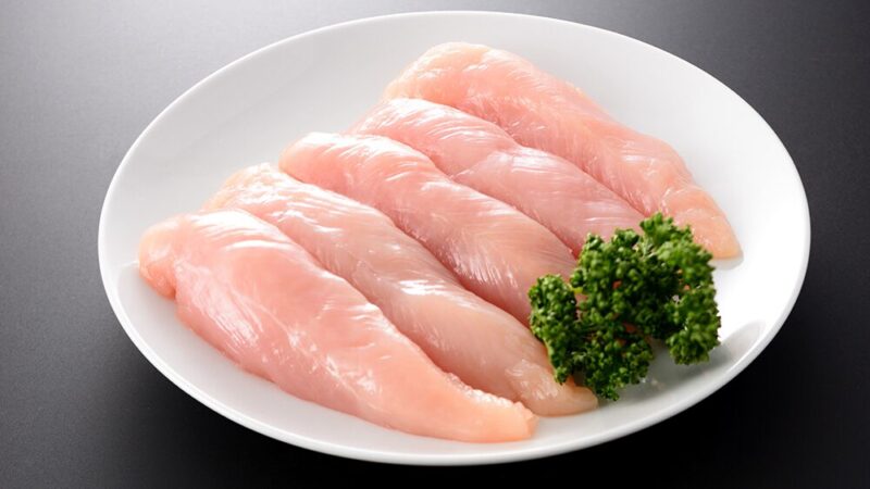 皿に乗った生の鶏ささみとパセリの写真