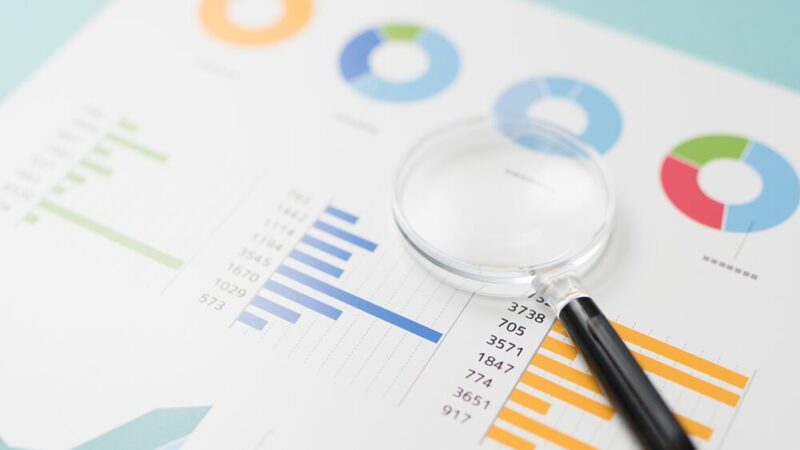 数値データと虫眼鏡の写真